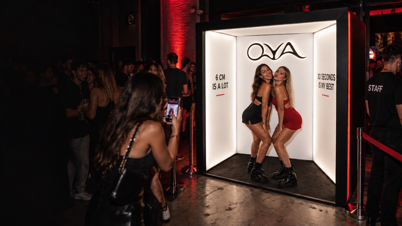 Concept della foto box OYA illuminata: due ospiti posano all’interno mentre viene scattata una foto
